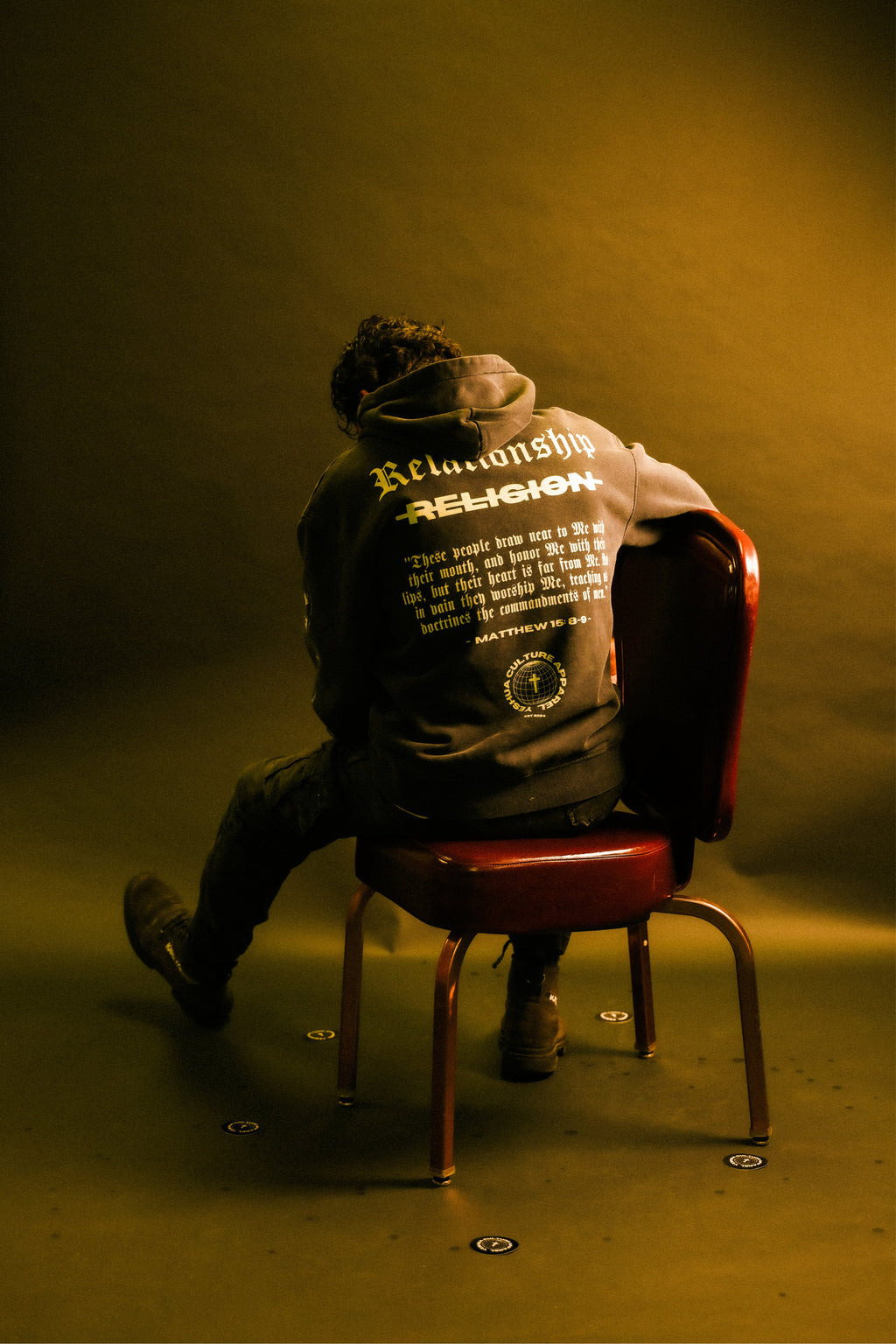 Man wearing ABOVE RELIGION Christian streetwear hoodie, warm lighting lifestyle shot
