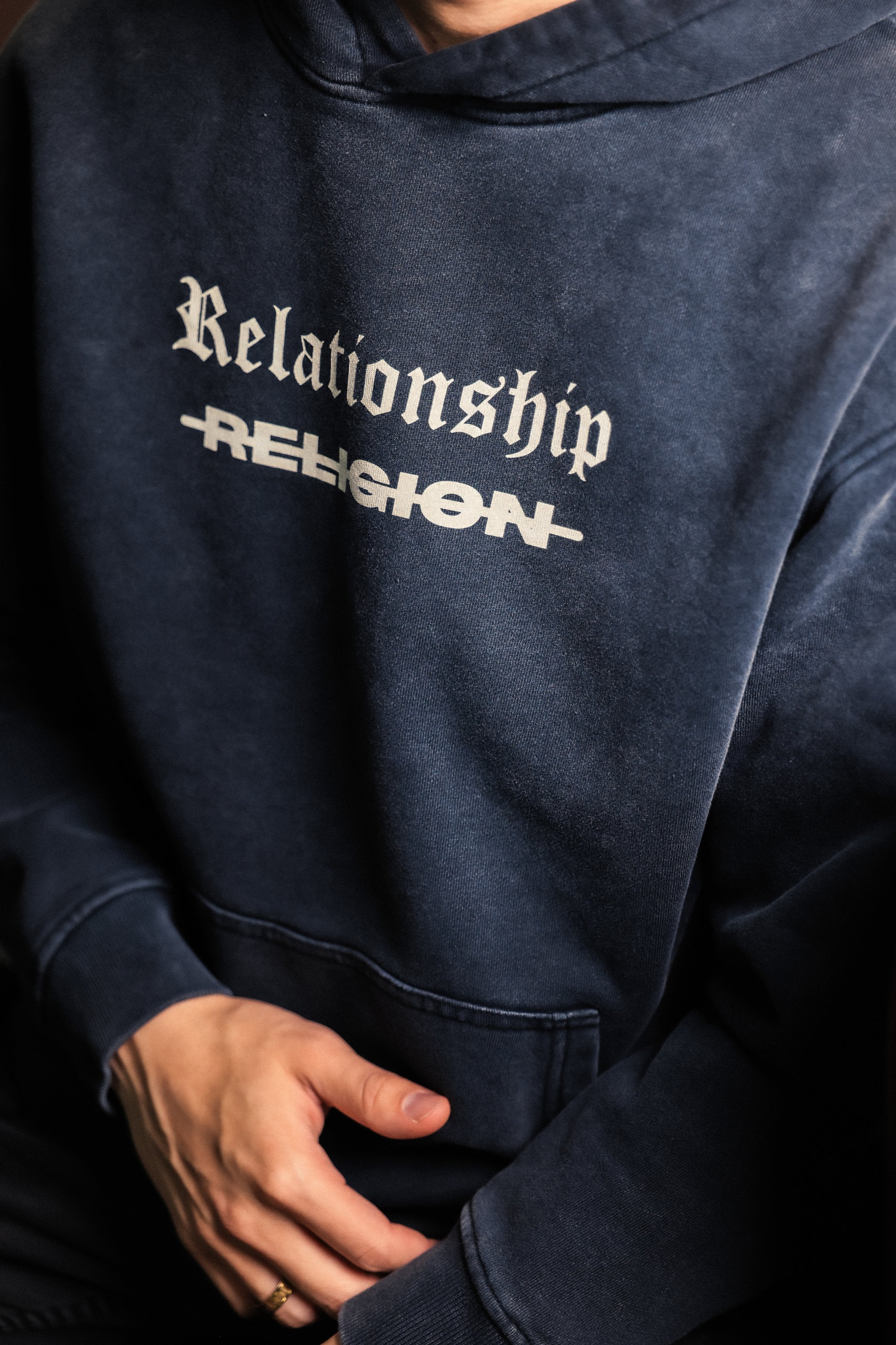Close-up of "Relationship over Religion" print on ABOVE RELIGION hoodie chest