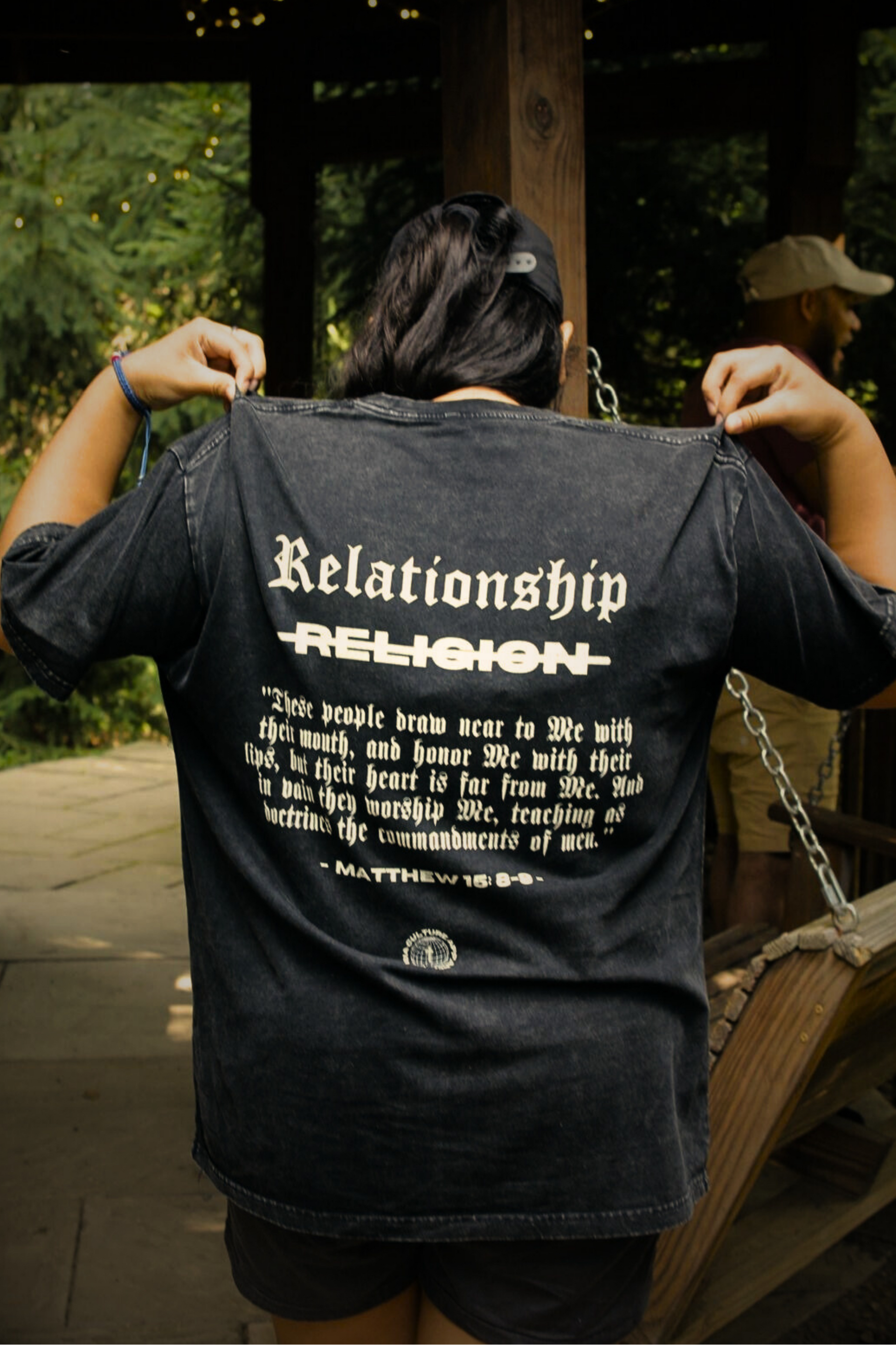 Back shot of female model wearing ABOVE RELIGION Oversized Christian Tee — relationship over religion