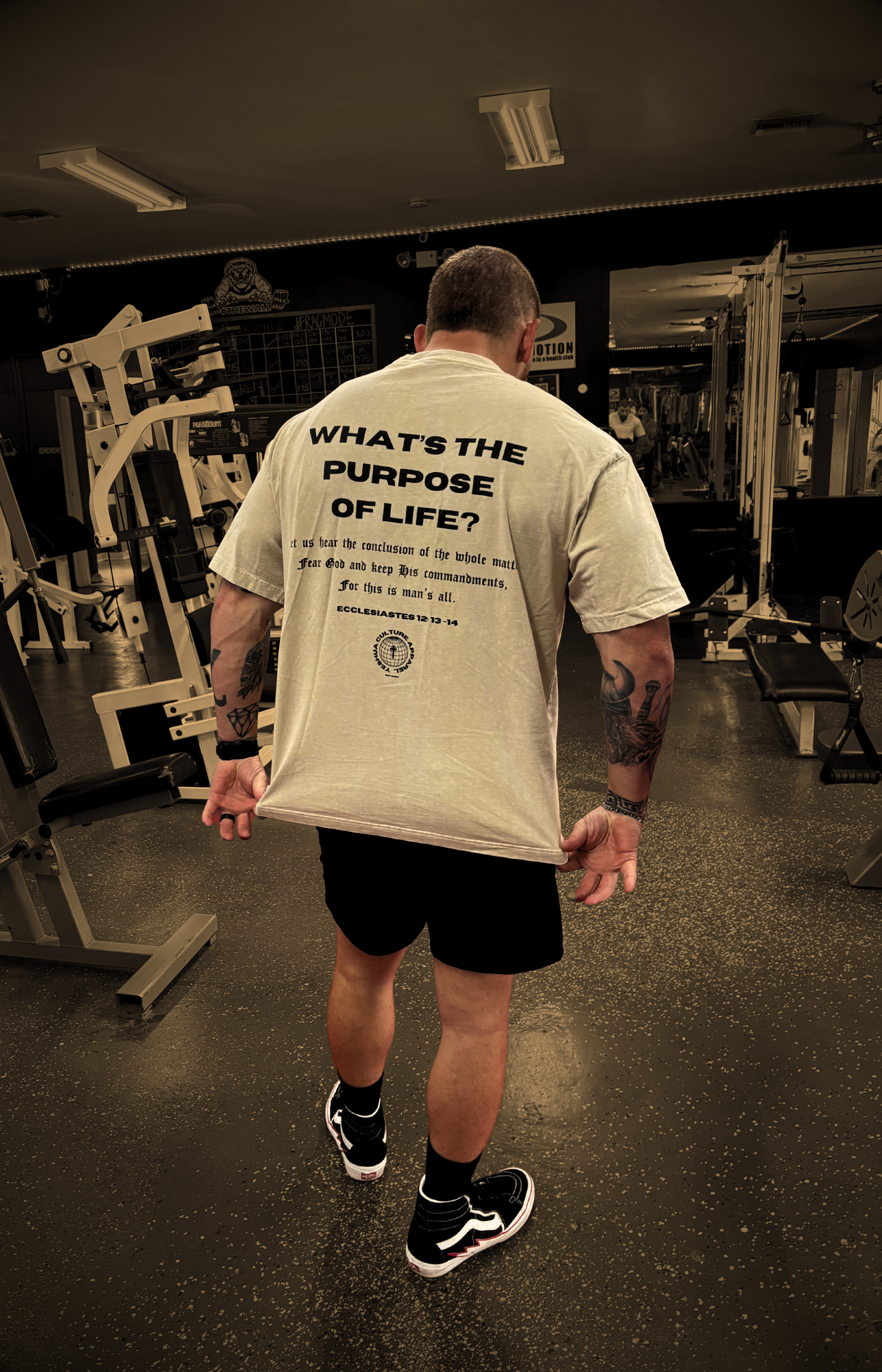 Back shot of model in gym wearing FEAR GOD Oversized Christian Tee — bold Christian streetwear