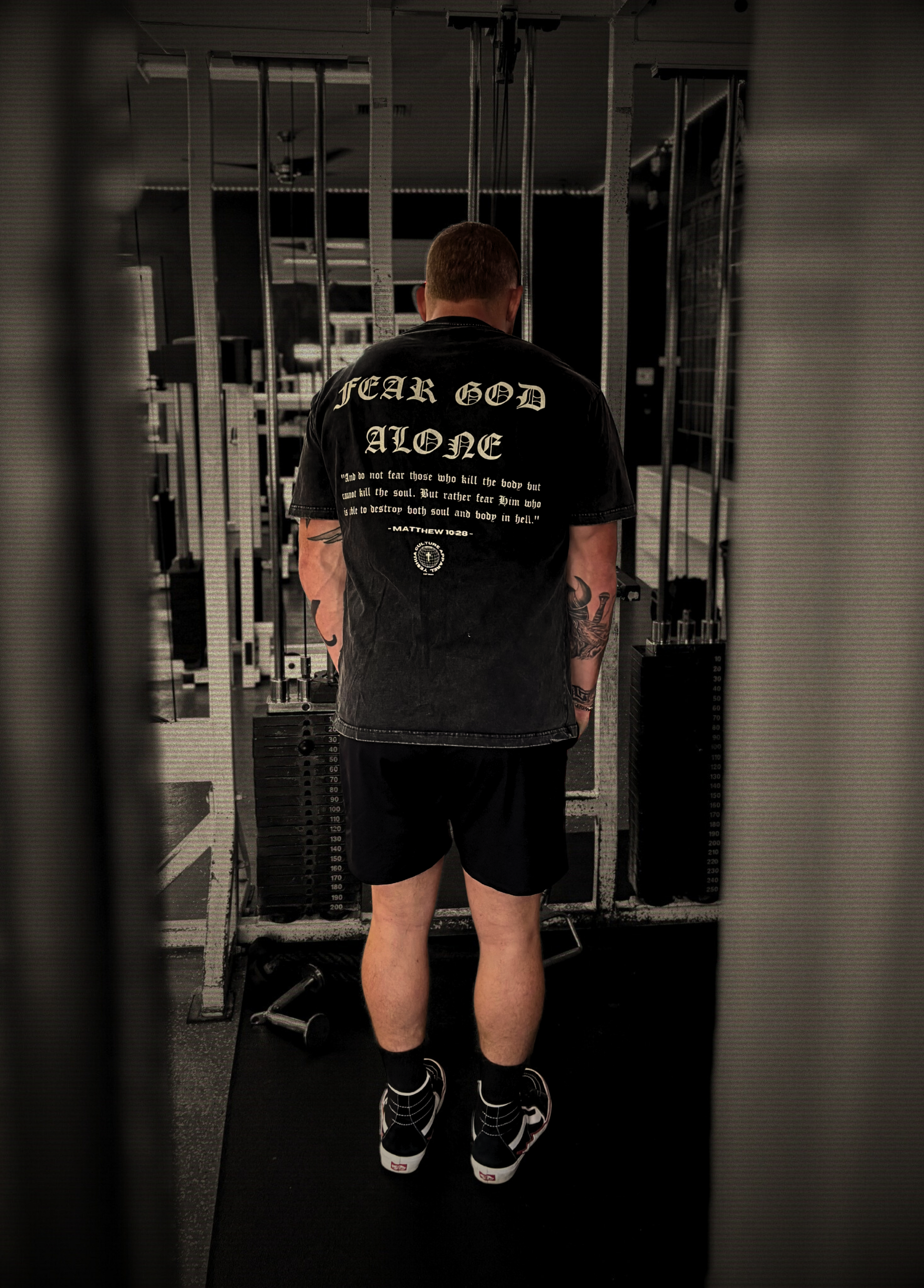 Back shot of model exercising in gym wearing FEARLESS FAITH Oversized Christian Tee — live unshaken