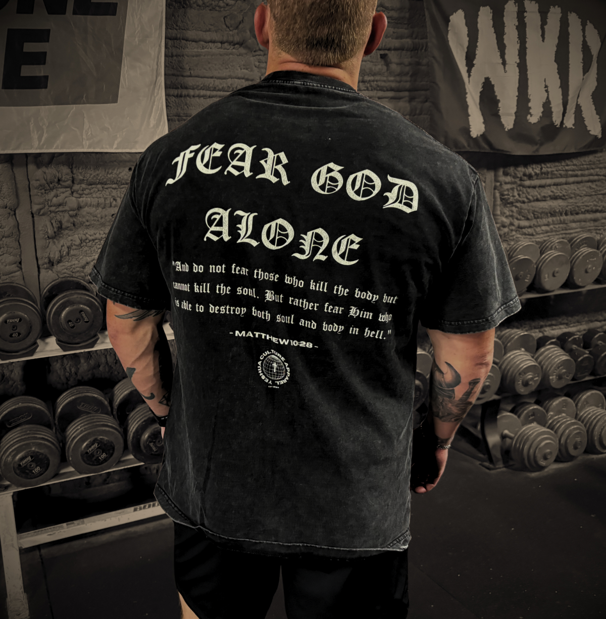 Man wearing FEARLESS FAITH Christian tee at the gym, back "FEAR GOD ALONE" graphic