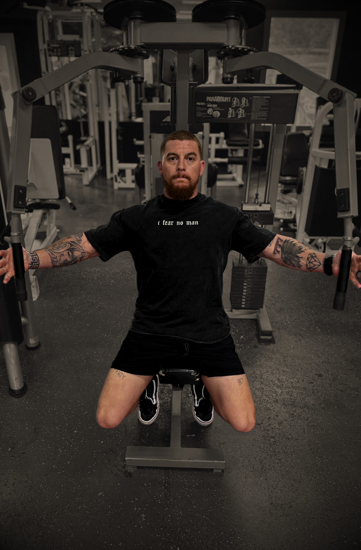 Man wearing FEARLESS FAITH tee on gym equipment, faith-based streetwear