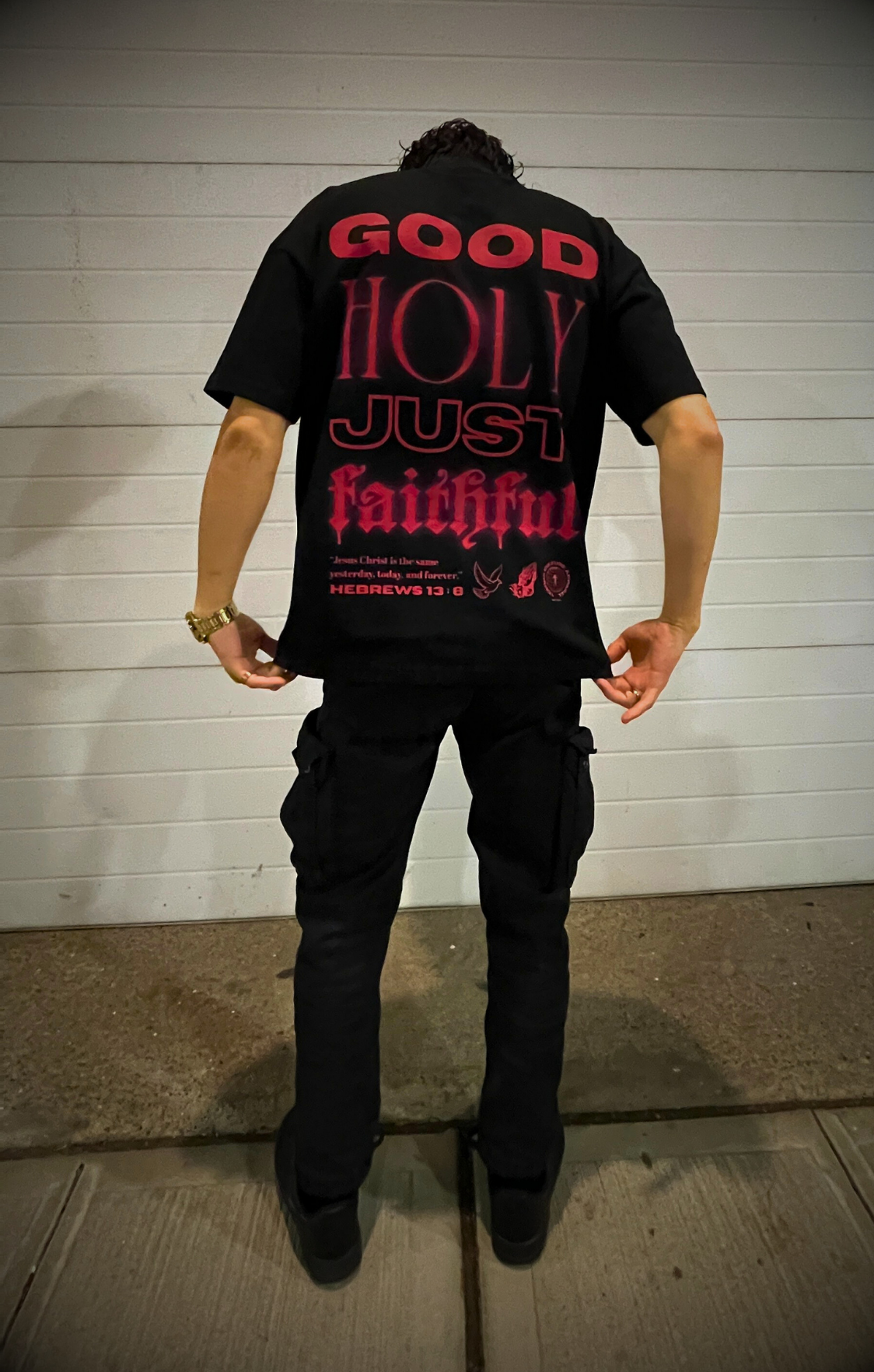 Back shot of male model wearing the GOD IS Oversized Te in Jet Black.