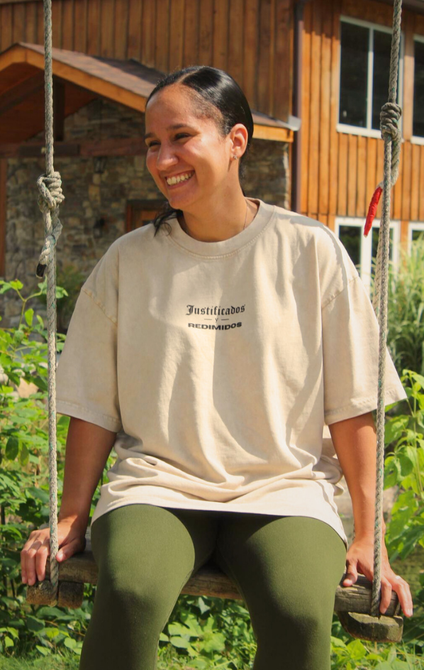 Vista delantera de modelo sentada usando JUSTIFICADOS Y REDIMIDOS Oversized Christian Tee — fe en movimiento