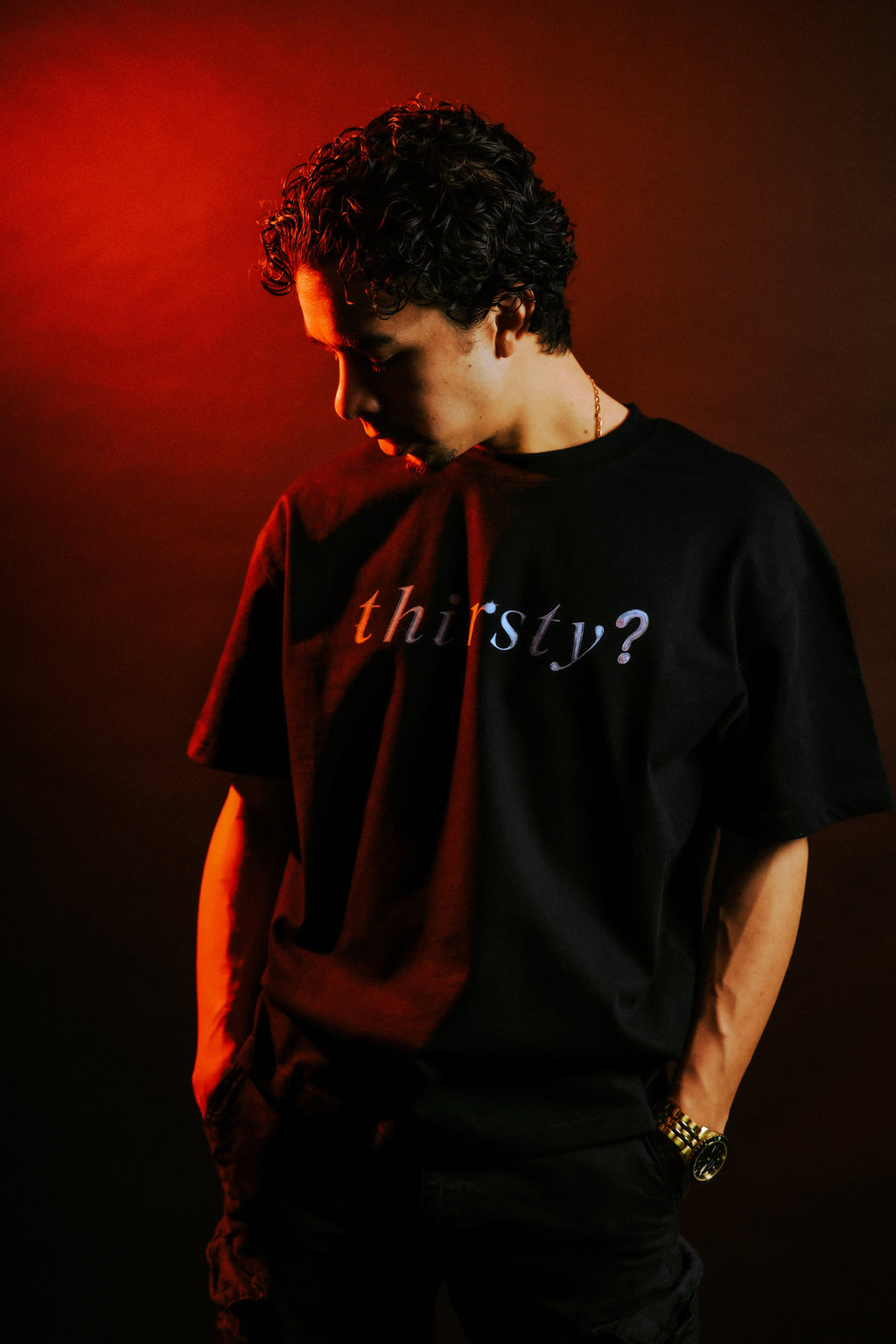 Man wearing LIVING WATER tee showing "thirsty?" chest print, side profile