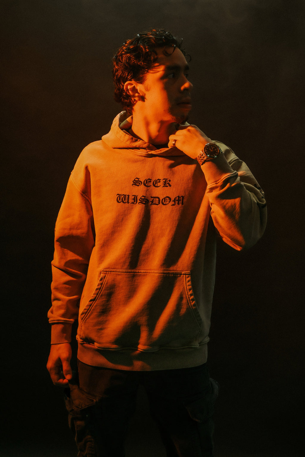 Man wearing SEEK WISDOM Christian hoodie, front view, studio lighting