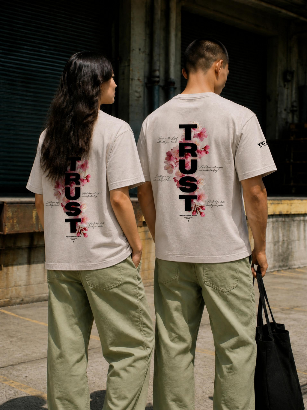 Back view of TRUST Tee 2.0 showing Proverbs 3:5-6 floral graphic on two models