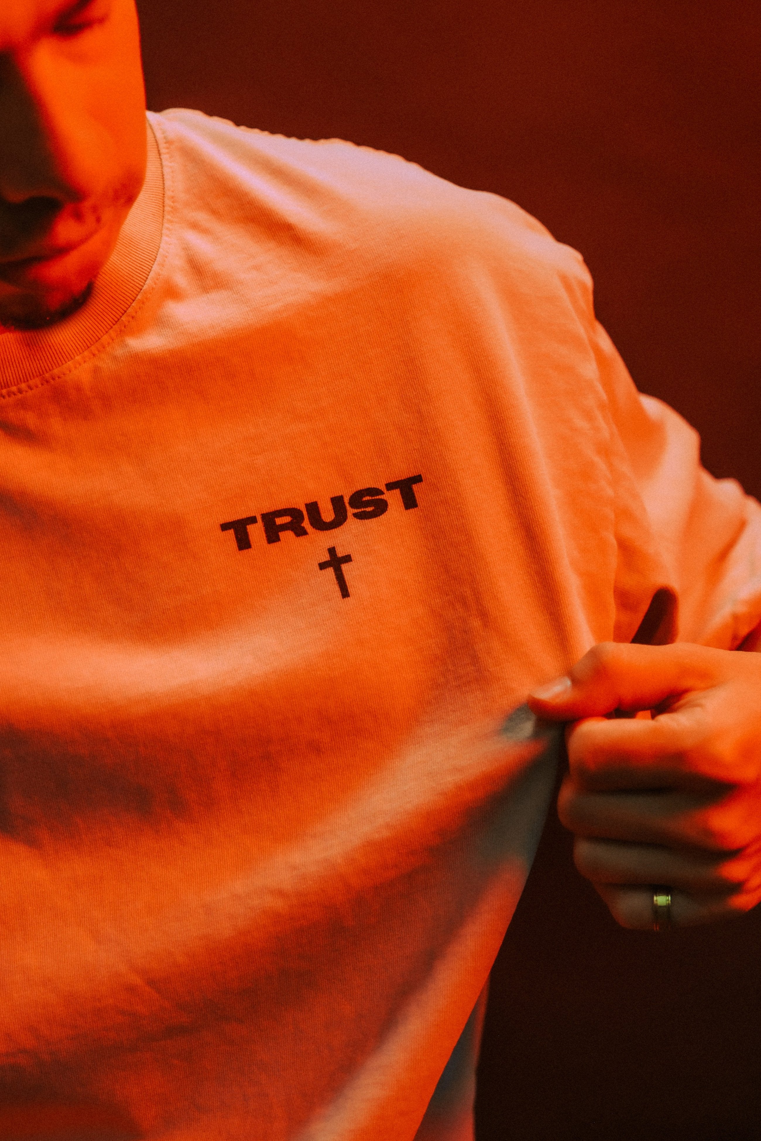 Close-up of TRUST chest print and cross icon on Christian tee